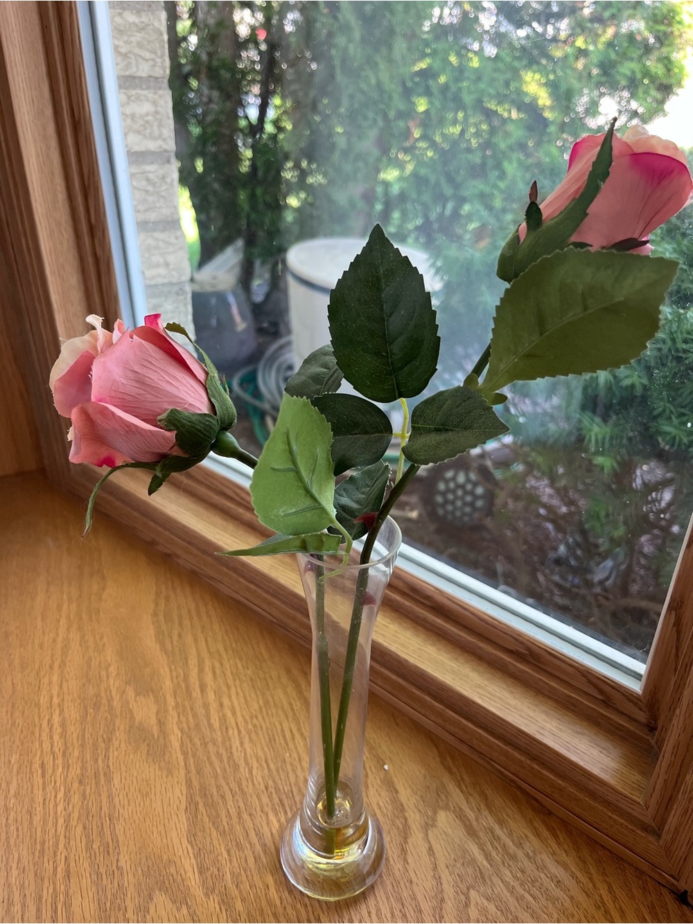 Artificial Pink Rose Buds in Glass Bud Vase. Two artificial pink rose buds with